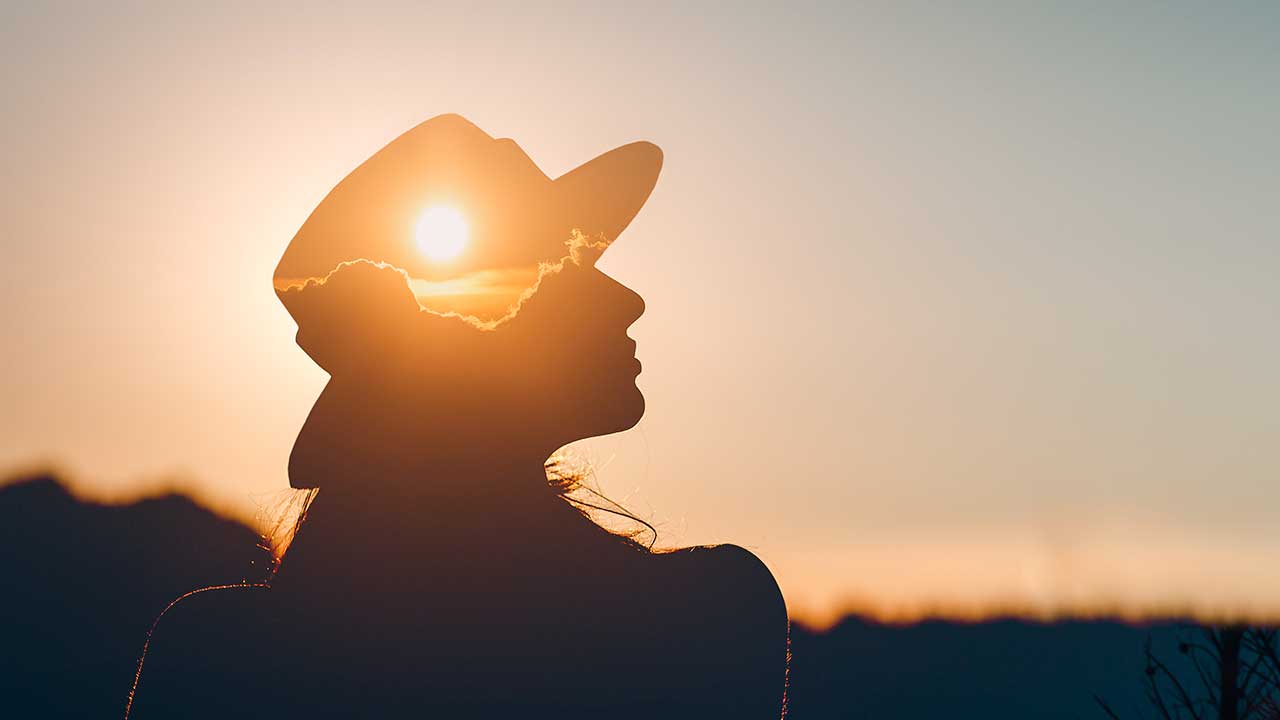 Silhouette einer Frau mit Sonne in ihrem Kopf