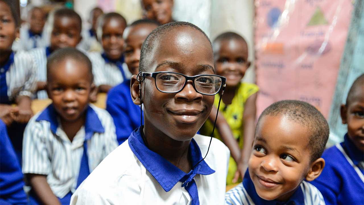 afrikanische Kinder, ein Junge trägt zufrieden eine Brille