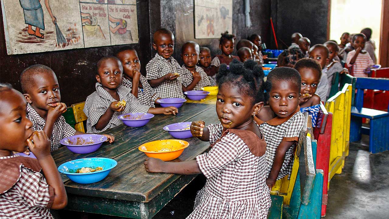 Afrikanische Kinder an einem Tisch beim Essen