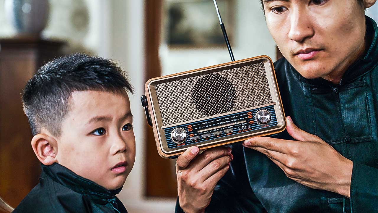 Asiatischer Junge und sein Vater hören Radio