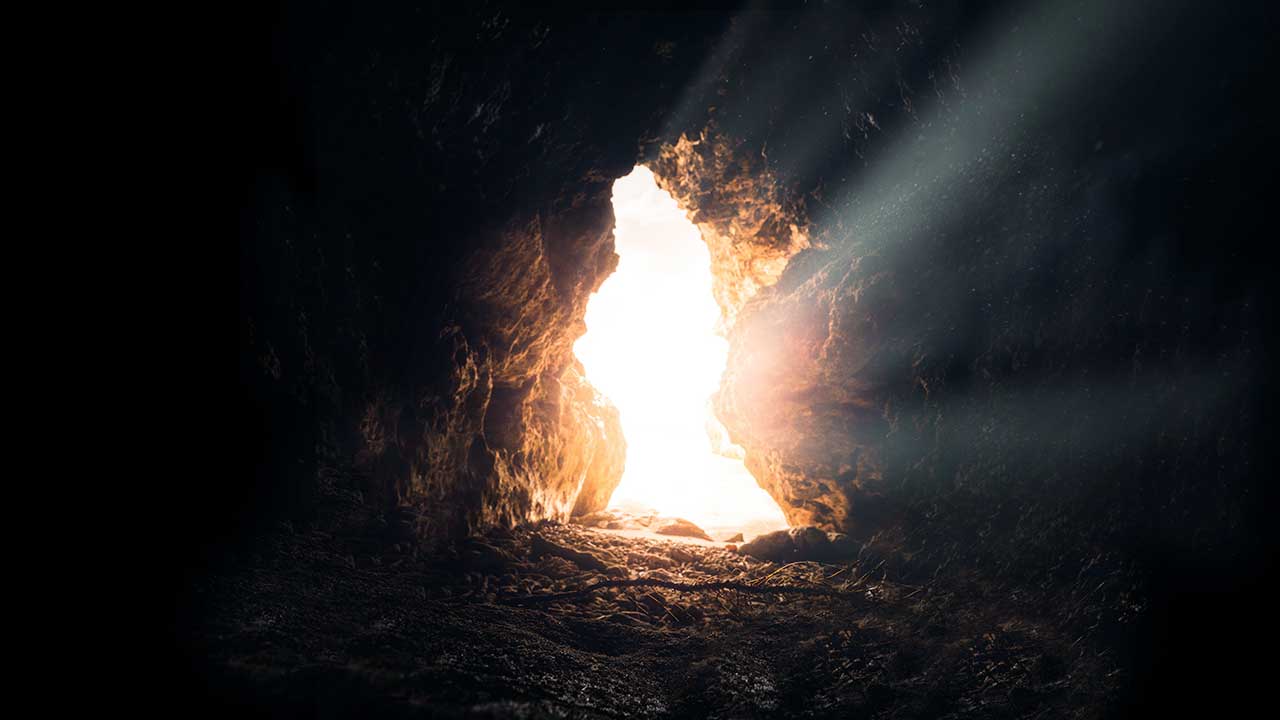 Blick aus einer Höhle hinaus, die durchflutet von Sonnenlicht ist