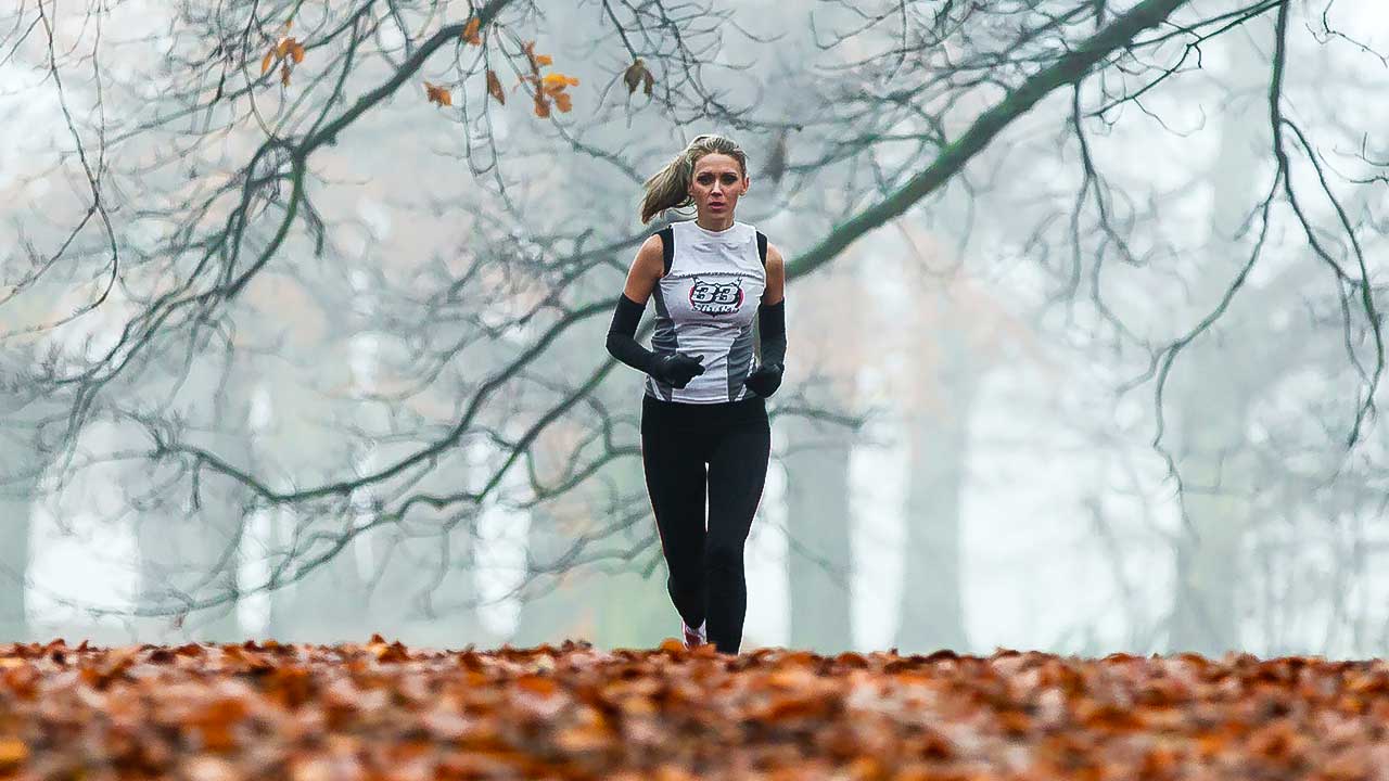 Frau joggt im herbstlichen Richmond Park in London