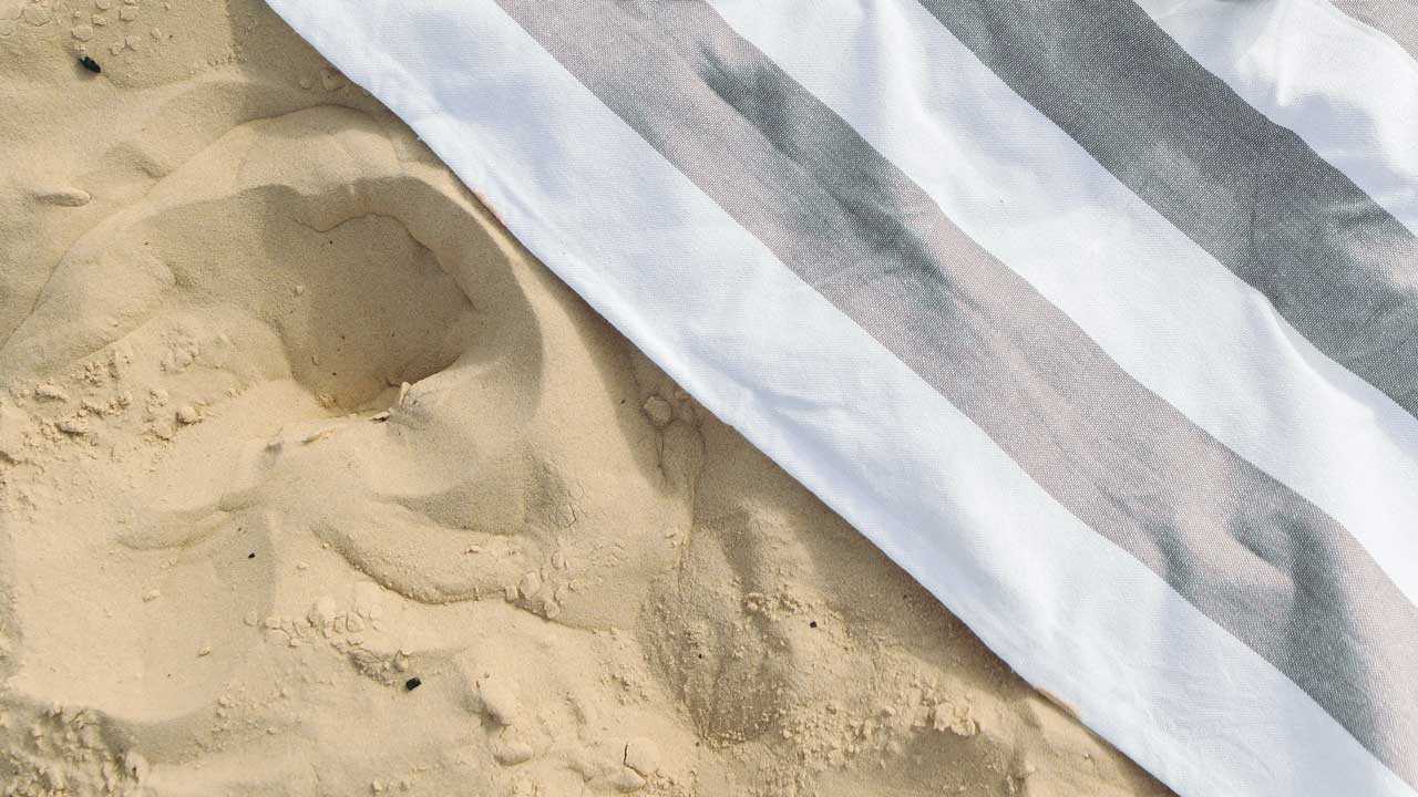 Ein Badetuch im Sand