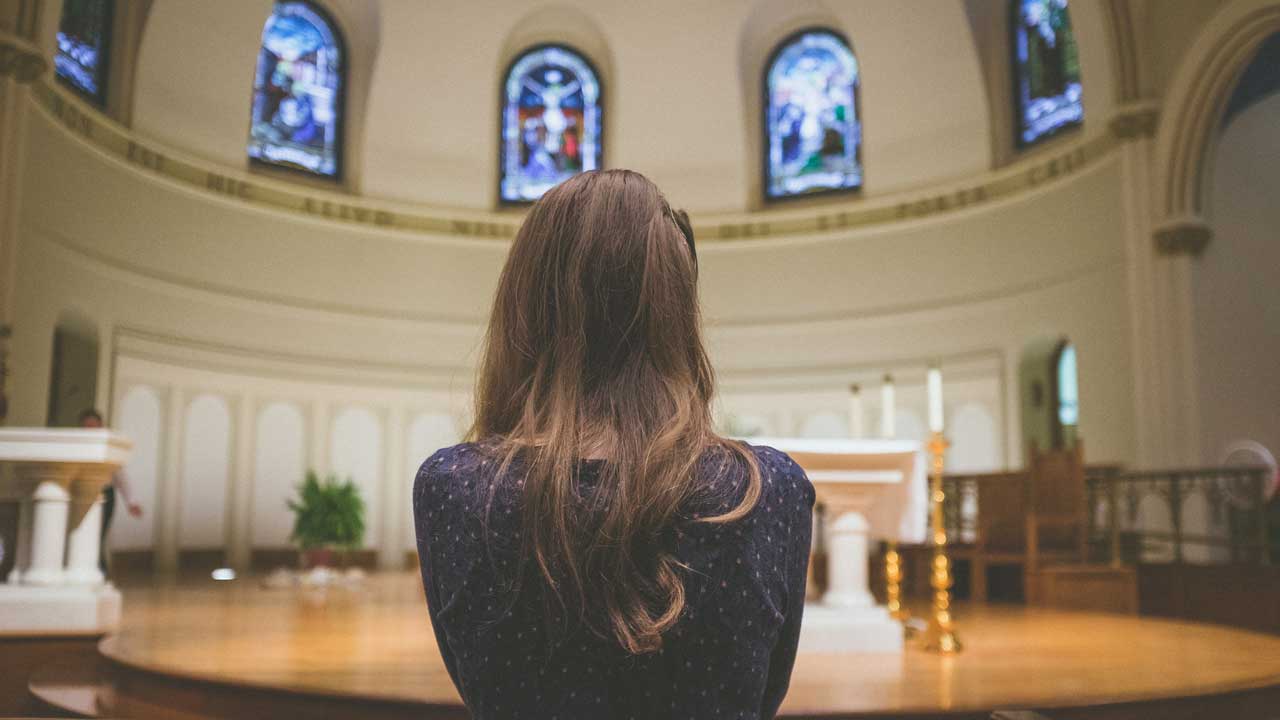 Eine Frau befindet sich allein in der Kirche - sie hat keinen Partner