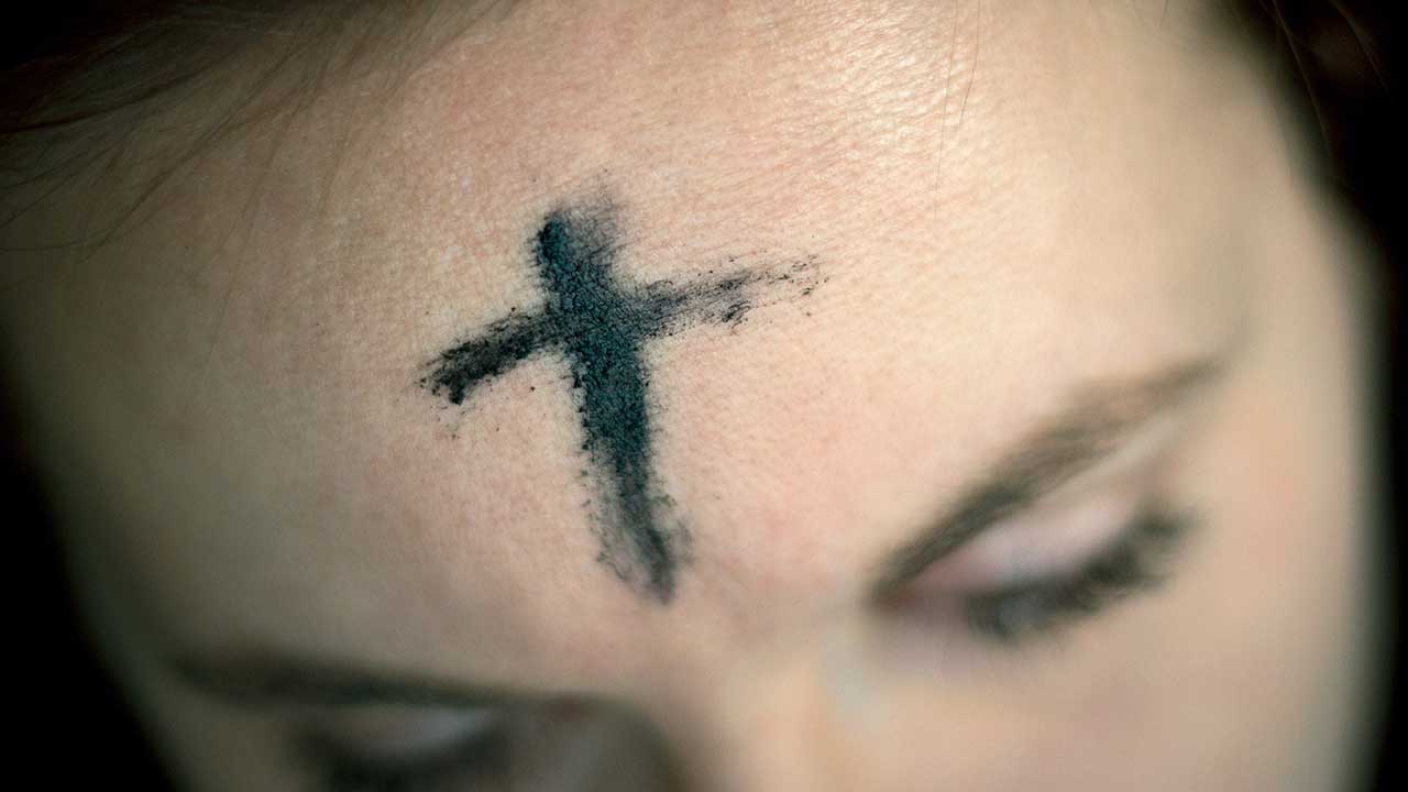 Aschermittwoch: Aschenkreuz auf der Stirn einer Frau