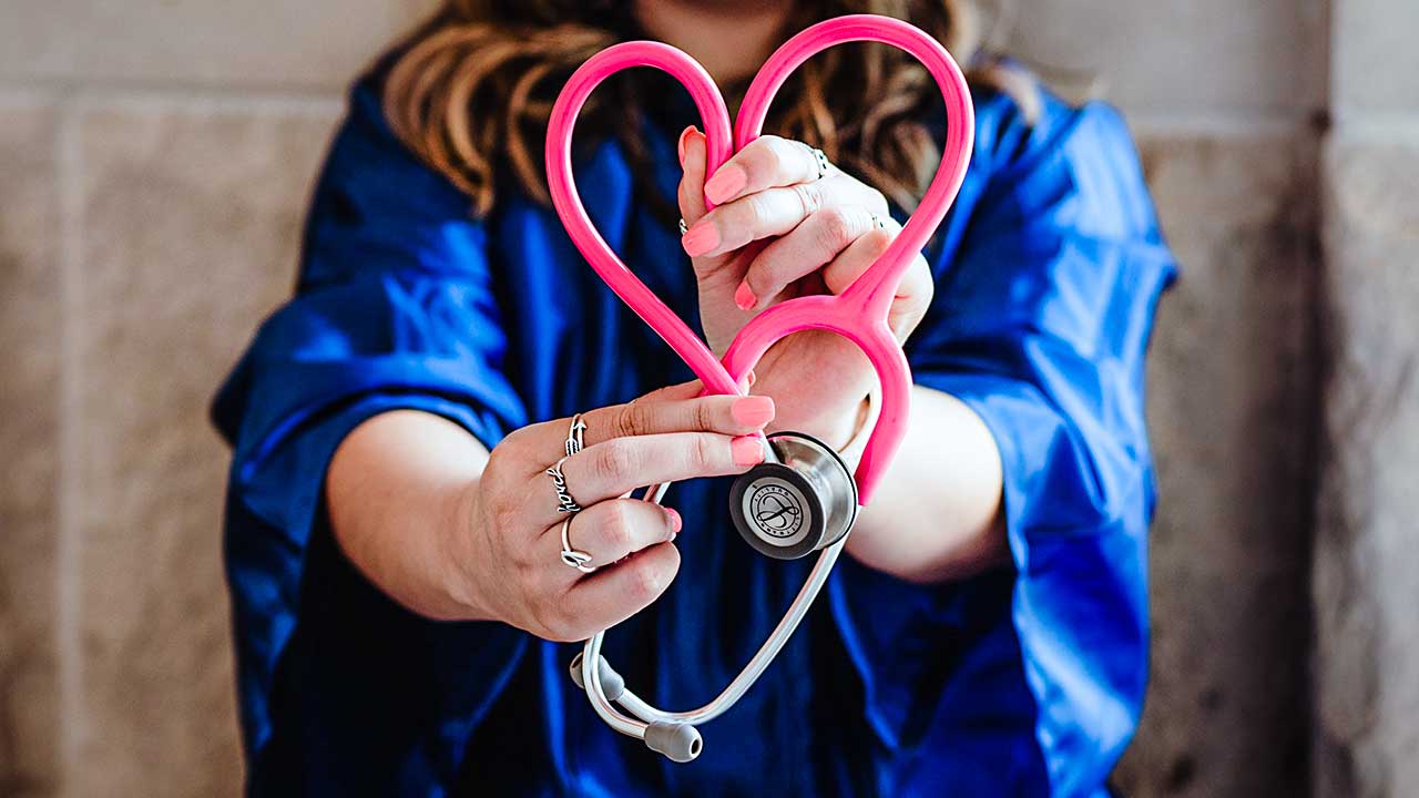 Frauenhände formen Stethoskop zu einem Herz