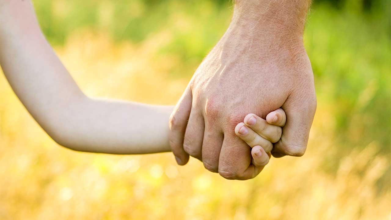 Kind und Vater halten Hände