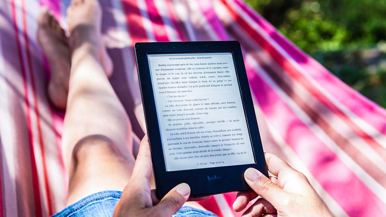 Person liegt in einer Hängematter und liest einen e-Reader