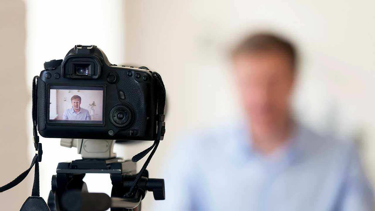Kamera macht Aufnahmen eines Mannes, beispielsweise eines Bloggers