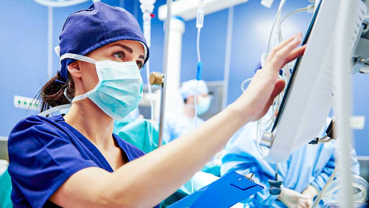 Krankenschwester bedient in einem Spital ein Gerät