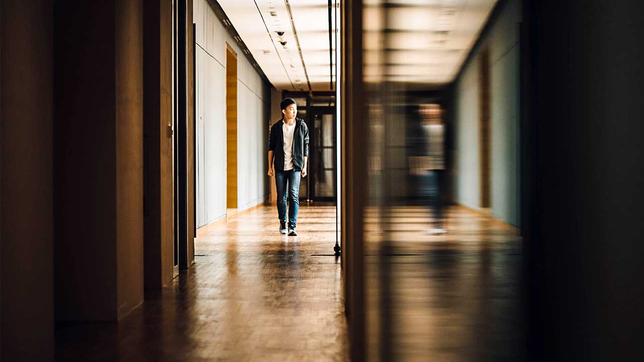 Schüler läuft durch einen Korridor eines Schulgebäudes