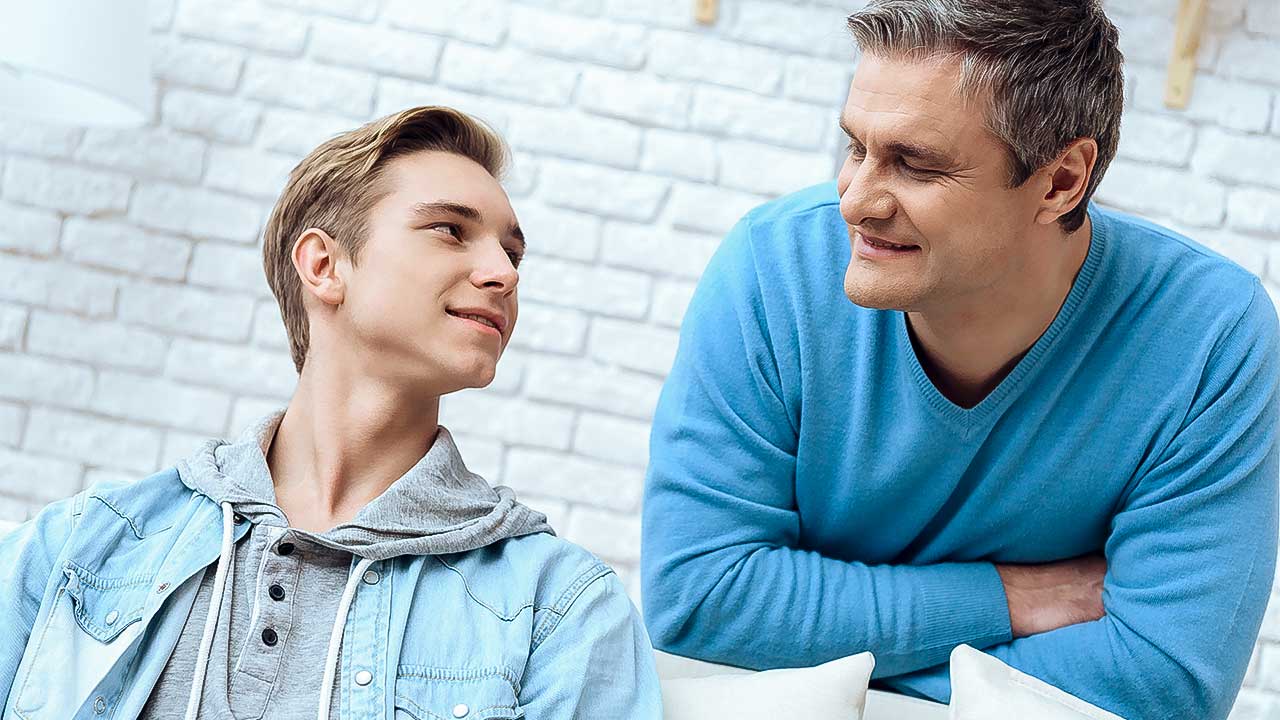 Vater und Teenager-Sohn schauen sich an