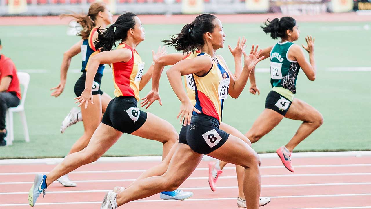 Sportlerinnen rennen auf einer Leichtathletikbahn