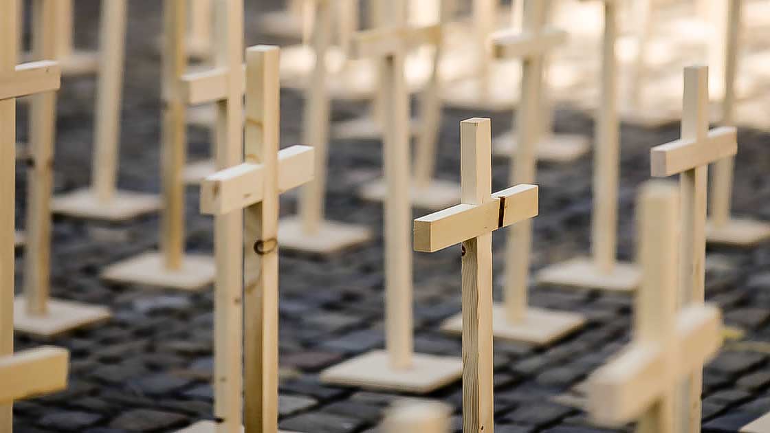 Holzkreuze als Symbolik für Massengrab
