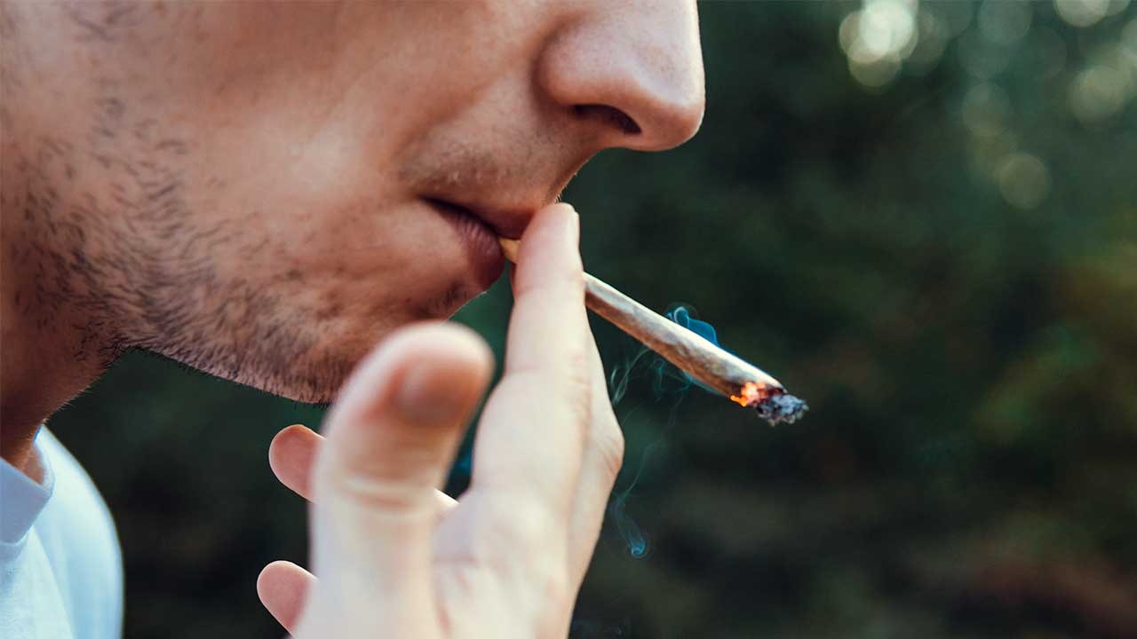 junger Mann raucht einen Marihuana-Joint