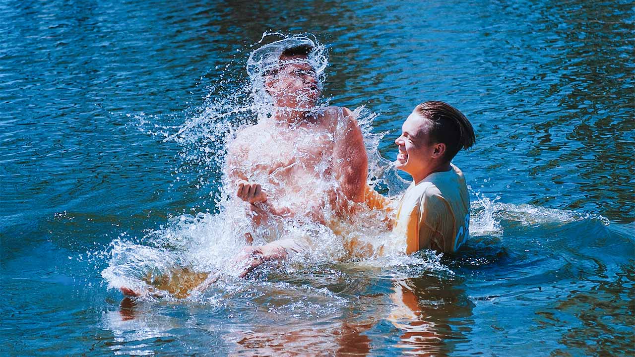 Ein Mann tauft einen anderen in einem Fluss.